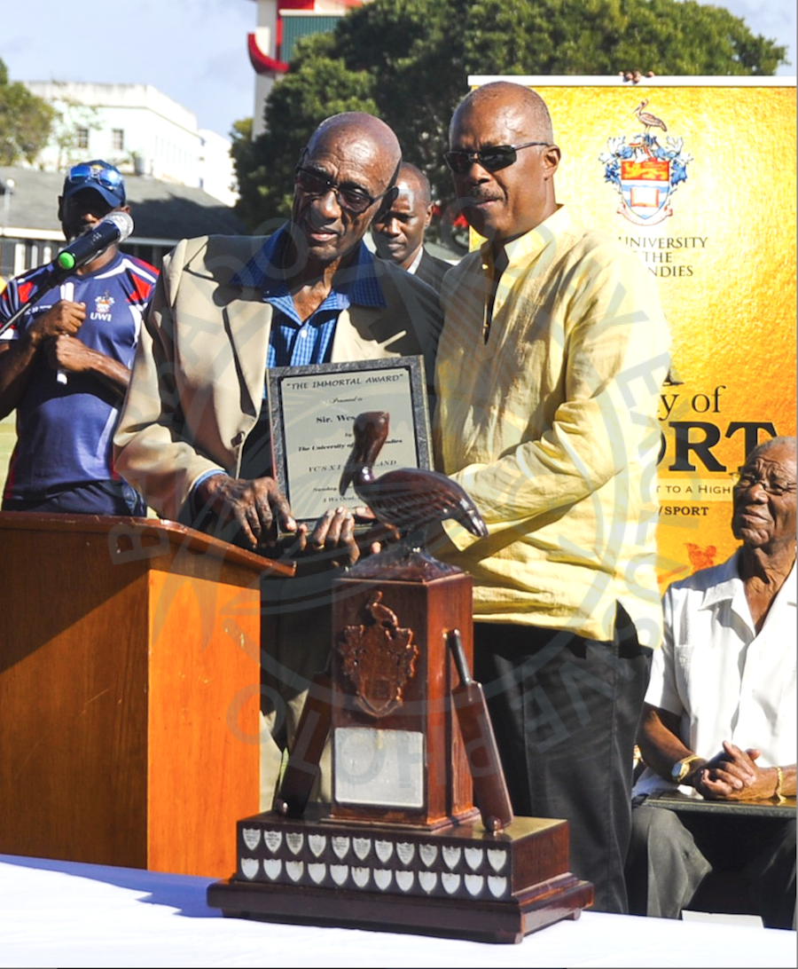 Sir Wes Hall (left) receiving his award from Professor Sir Hillary Beckles. Sitting at right is Sir Everton Weekes.