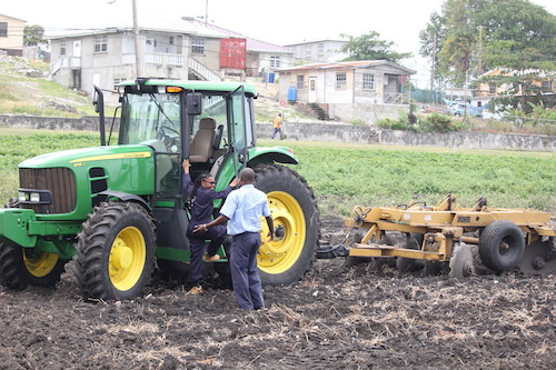 FEED participant Cherita Olton (left) about to climb into a tractor to start learning how to operate it.