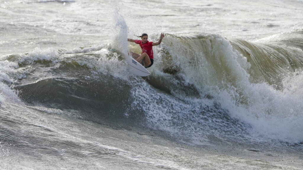 Tuach rides a wave in regional surfing